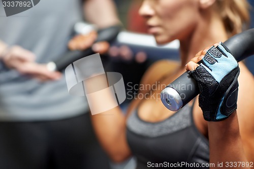 Image of man and woman flexing muscles on gym machine