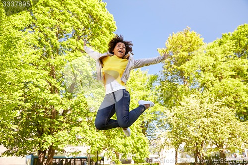 Image of happy african american young woman in summer park