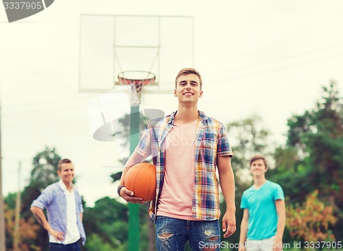 Image of group of smiling teenagers playing basketball