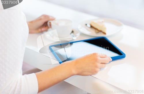 Image of close up of woman with tablet pc drinking coffee