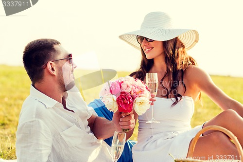 Image of smiling couple drinking champagne on picnic