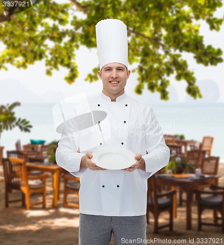 Image of happy male chef cook showing empty plate