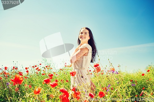 Image of smiling young woman on poppy field