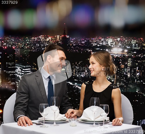 Image of smiling couple looking at each other at restaurant