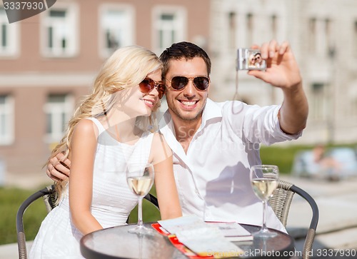 Image of couple taking photo in cafe