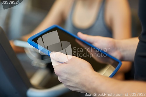 Image of close up of trainer hands with tablet pc in gym