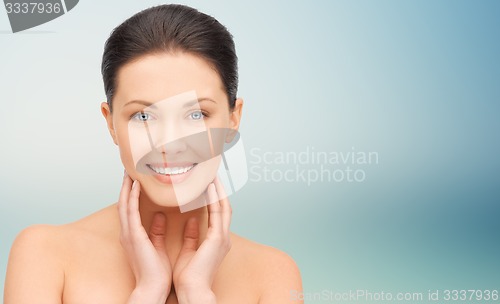 Image of beautiful young woman touching her face and neck