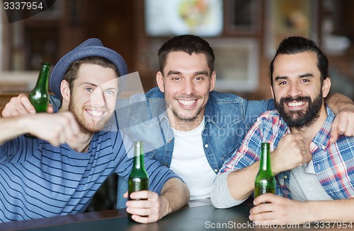 Image of happy male friends drinking beer at bar or pub