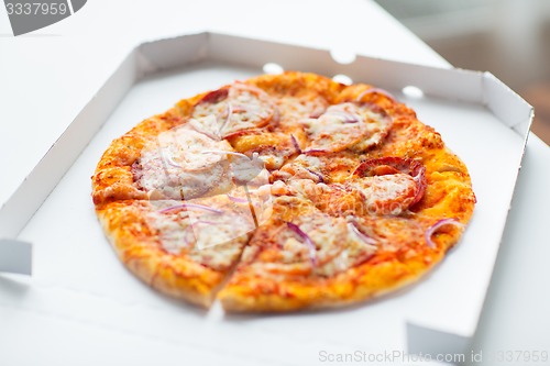 Image of close up of pizza in paper box on table