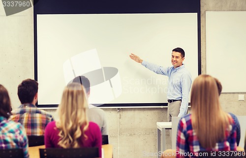 Image of group of students and smiling teacher in classroom