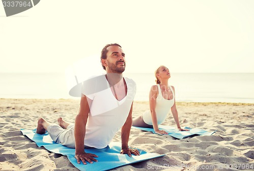 Image of couple making yoga exercises outdoors