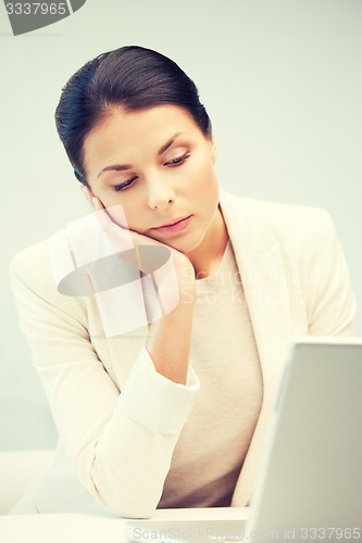 Image of pensive woman with laptop computer