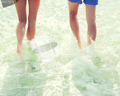 Image of close up of human legs on summer beach