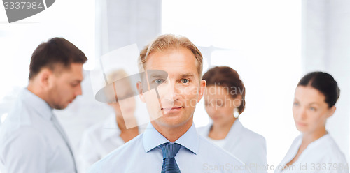 Image of businessman in office with group on the back