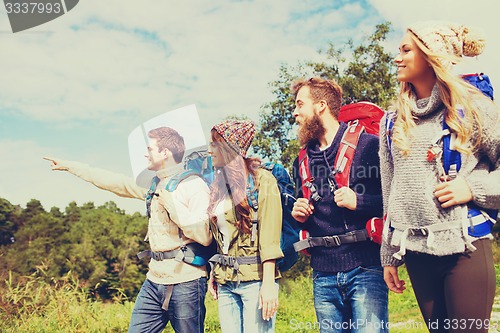 Image of group of smiling friends with backpacks hiking