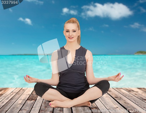 Image of happy young woman meditating in yoga lotus pose