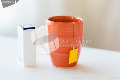 Image of close up of sweetener and tea cup on table