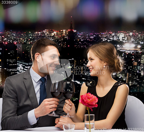Image of young couple with glasses of wine at restaurant