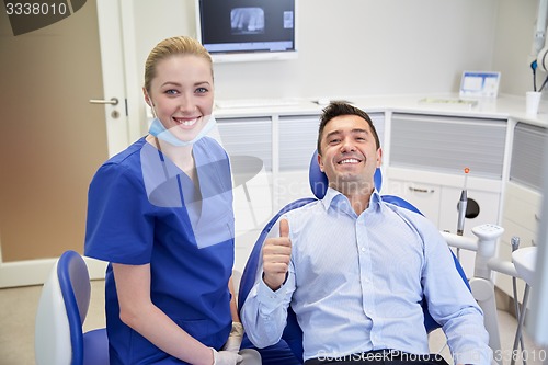 Image of happy female dentist with man patient at clinic