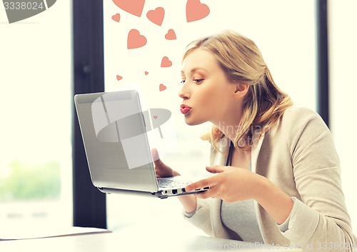 Image of woman with computer kissing the screen