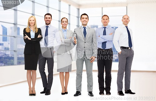 Image of group of smiling businessmen making handshake