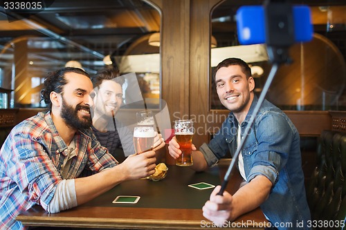 Image of friends taking selfie and drinking beer at bar