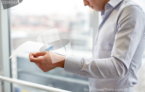 Image of businessman with clipboard and papers in office