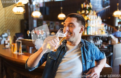 Image of happy man drinking beer at bar or pub