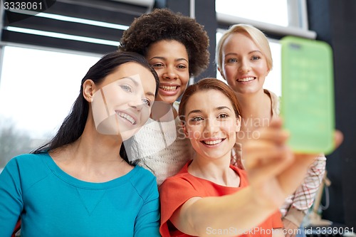 Image of happy young women taking selfie with smartphone