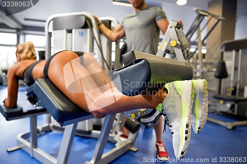 Image of man and woman flexing muscles on gym machine