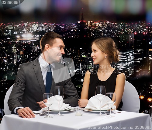 Image of smiling couple looking at each other at restaurant