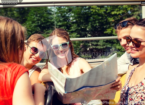 Image of group of smiling friends traveling by tour bus