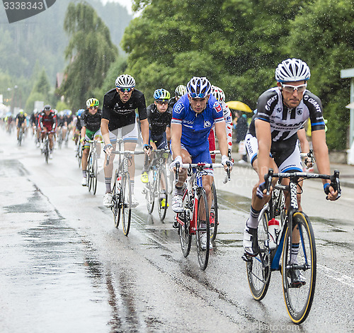 Image of The Peloton Riding in the Rain - Tour de France 2014