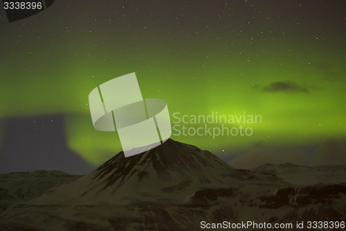 Image of Northern lights with snowy mountains in the foreground