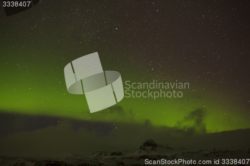 Image of Northern lights with snowy mountains in the foreground