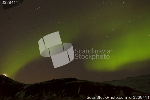 Image of Northern lights with snowy mountains in the foreground