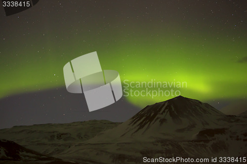 Image of Northern lights with snowy mountains in the foreground