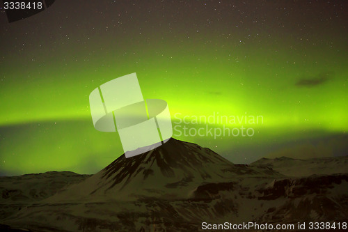 Image of Northern lights with snowy mountains in the foreground