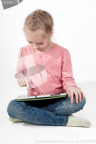 Image of Little girl uses a tablet PC