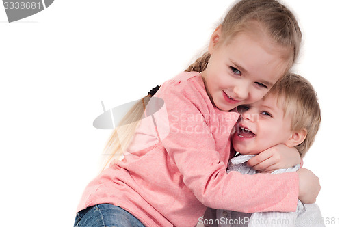 Image of Brother and sister hugging in studio