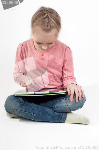 Image of Little girl uses a tablet PC