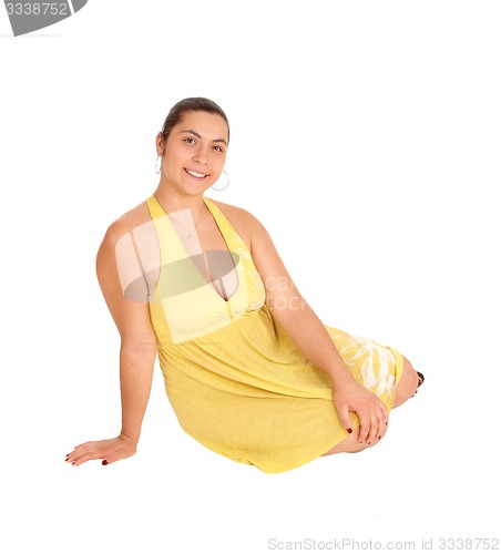 Image of Young woman sitting in yellow dress.