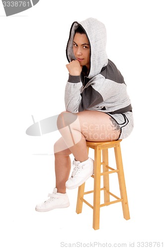 Image of Girl sitting in hoodie on a chair.