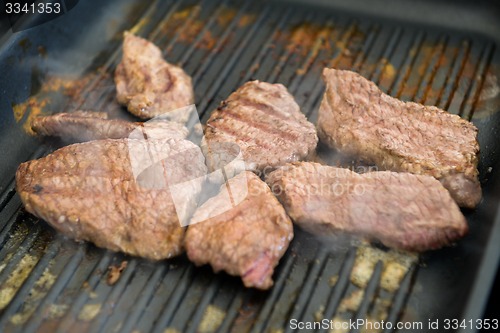 Image of cooking steaks on a hot grill