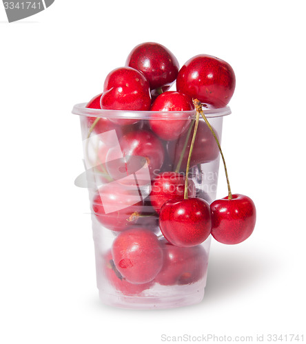 Image of Red juicy sweet cherries in a plastic cup