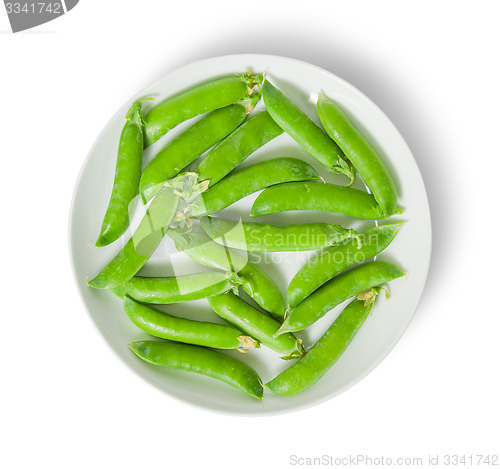 Image of Several pods of peas on a white plate top view