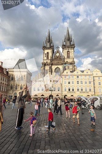 Image of PRAGUE, CZECH REPUBLIC - May 08, 2013: A man doing huge bubbles and amazed kids. Street Art.