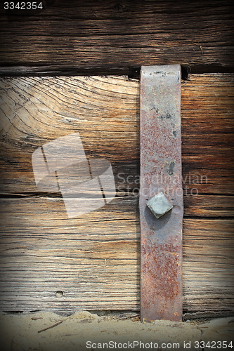 Image of metal mount on old wooden beam