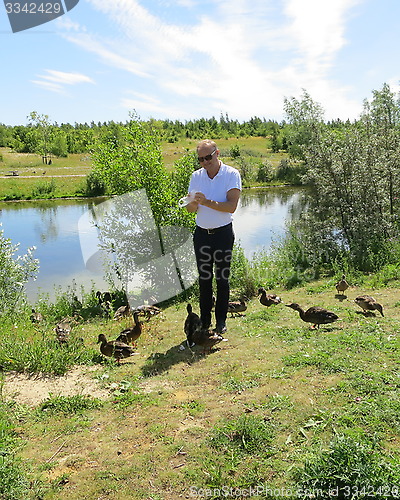 Image of Man feeding ducks