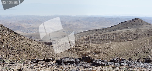 Image of Desert landscape with far Bedouin camp on hazy day